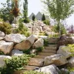 A serene rock garden featuring steps that ascend towards a charming house, showcasing the beauty of Laytonscape design.