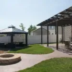 A serene backyard featuring a cozy fire pit surrounded by a gazebo, perfect for relaxation and gatherings.